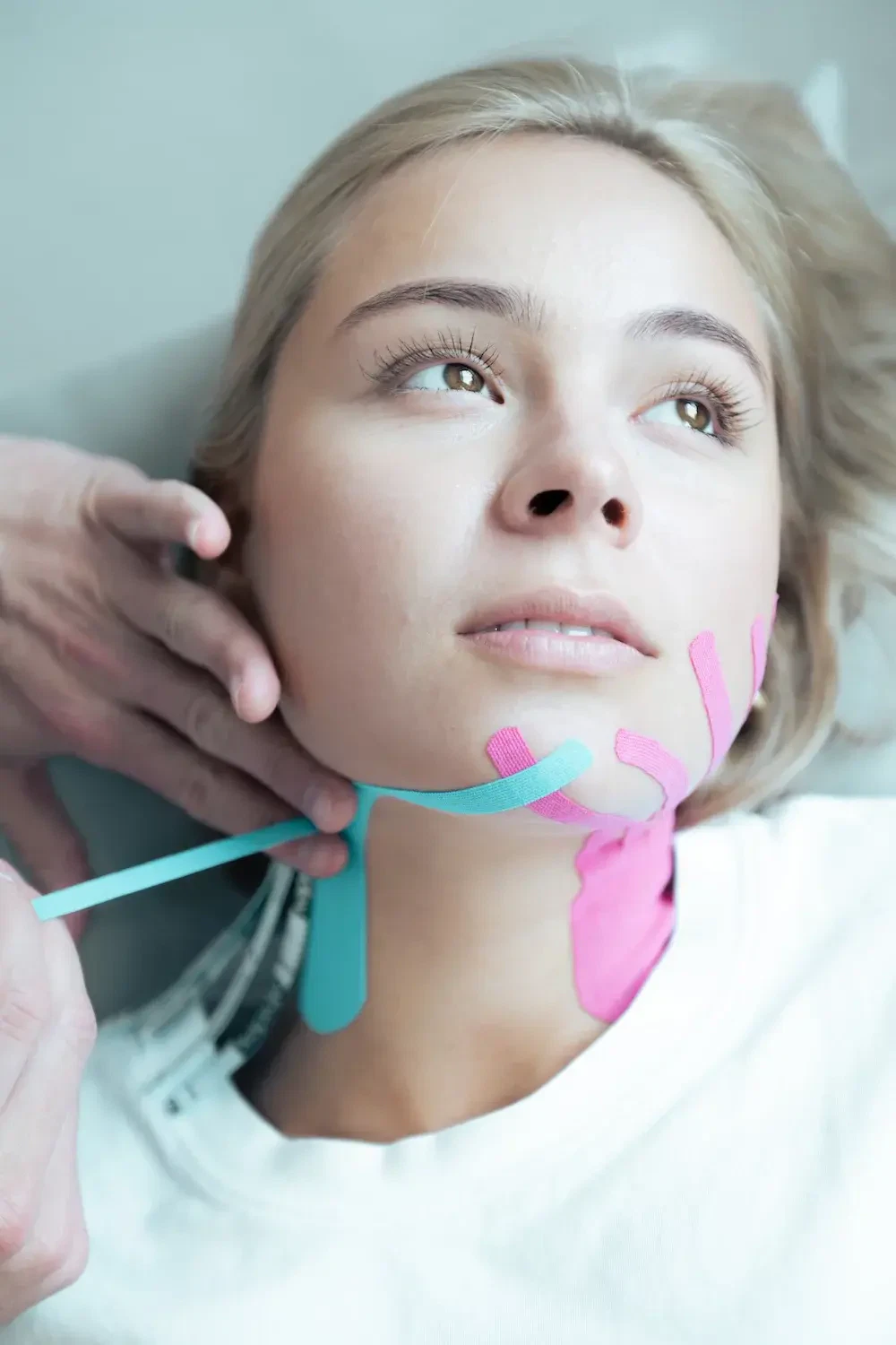 Patientin mit Kinesio-Tape am Kiefer und Hals bei CMD Physiotherapie in Karlsruhe für Kiefergelenk, Kopf und Nacken