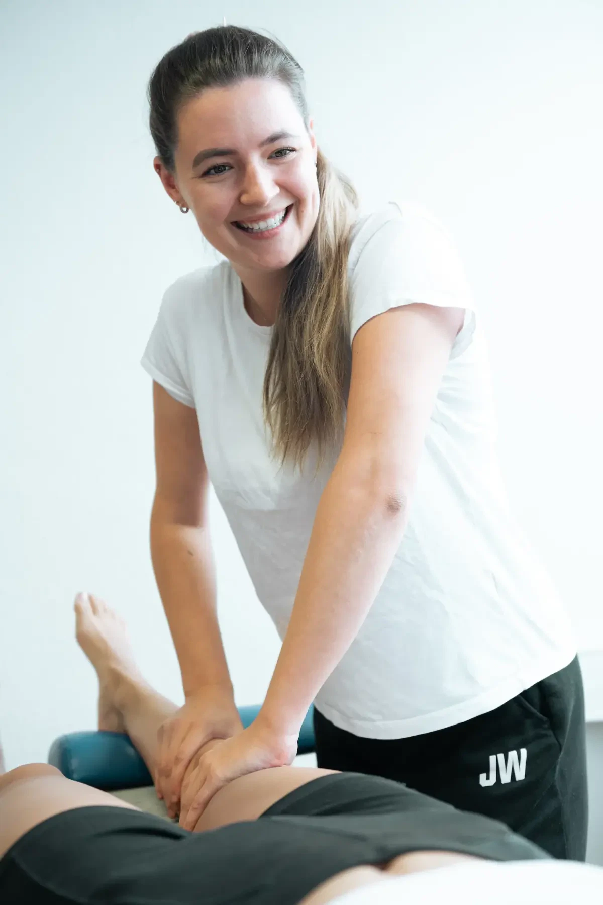 Physiotherapeutin führt eine manuelle Behandlung am Bein eines Patienten in einer Praxis für Physiotherapie in Karlsruhe durch